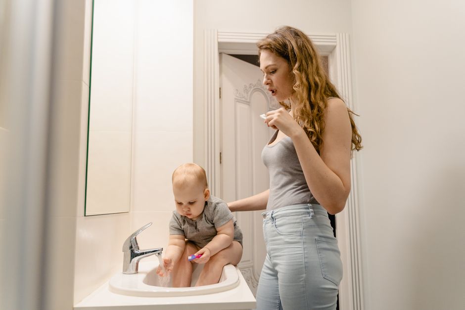 toddler brushing teeth with parent