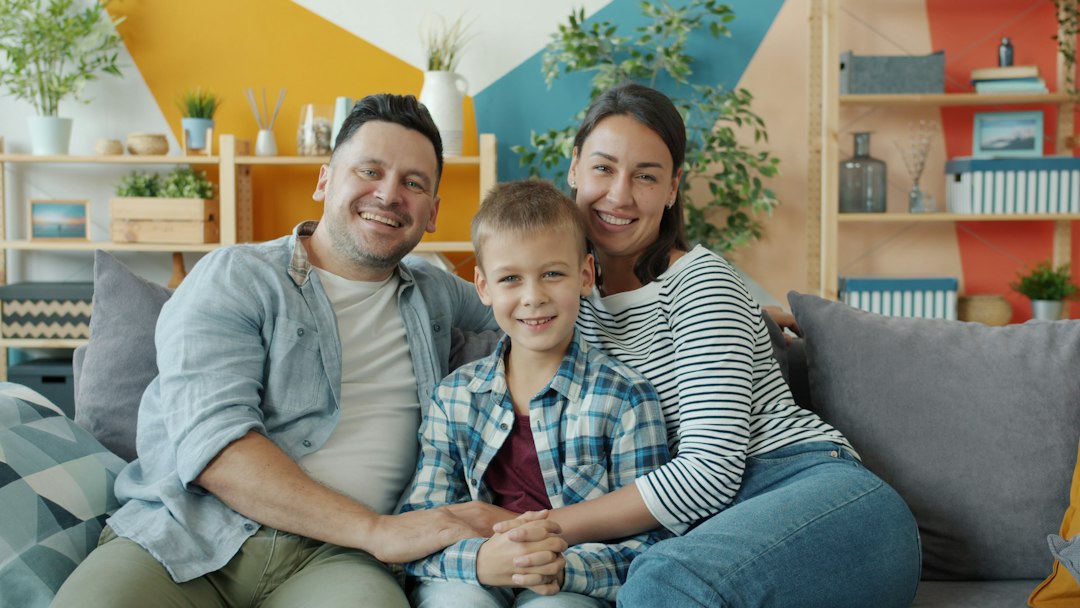 A family sitting together on a couch talking calmly A family sitting together on a couch talking calmly